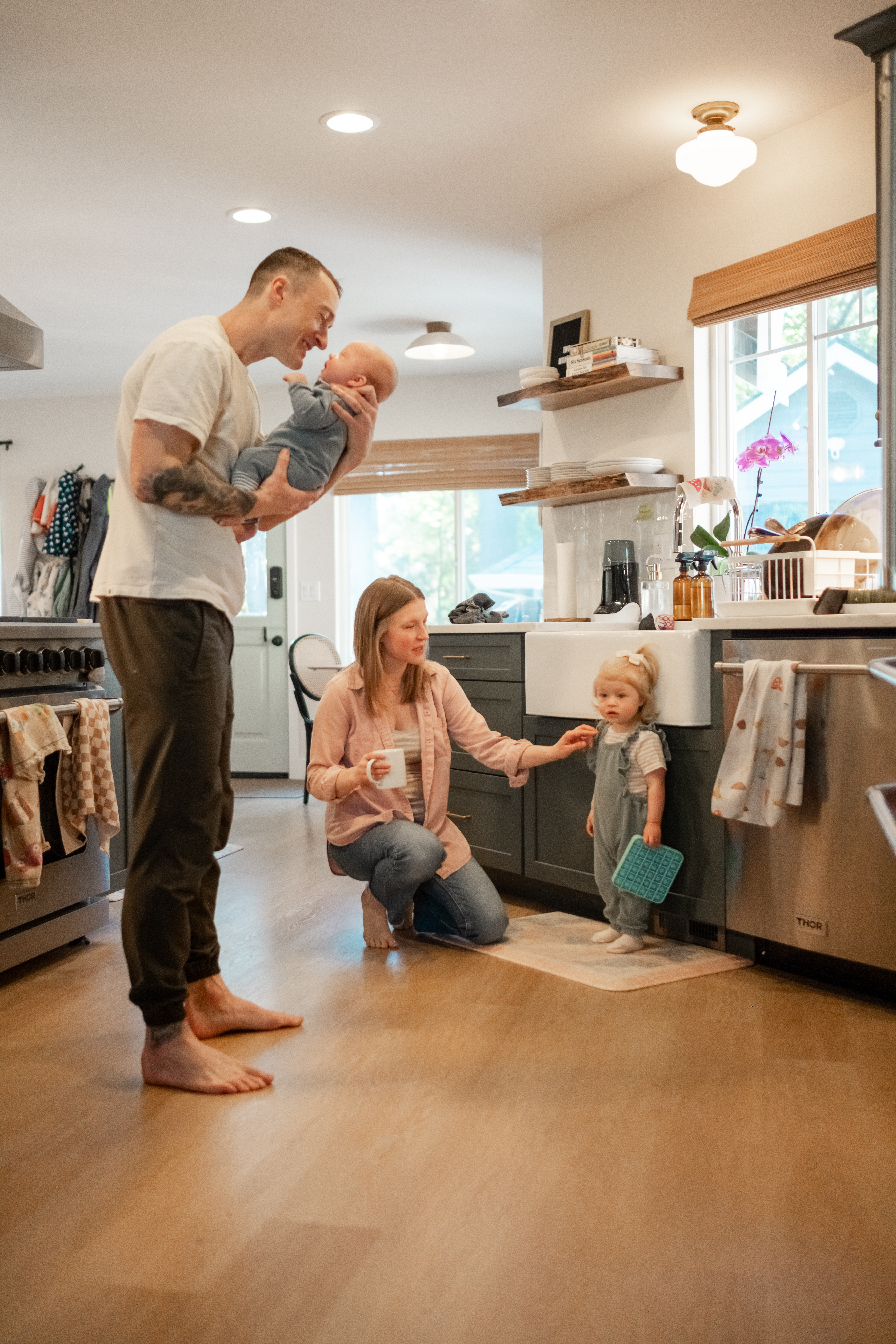 Seattle family with small infant and toddler standing in their kitchen during afternoon routine