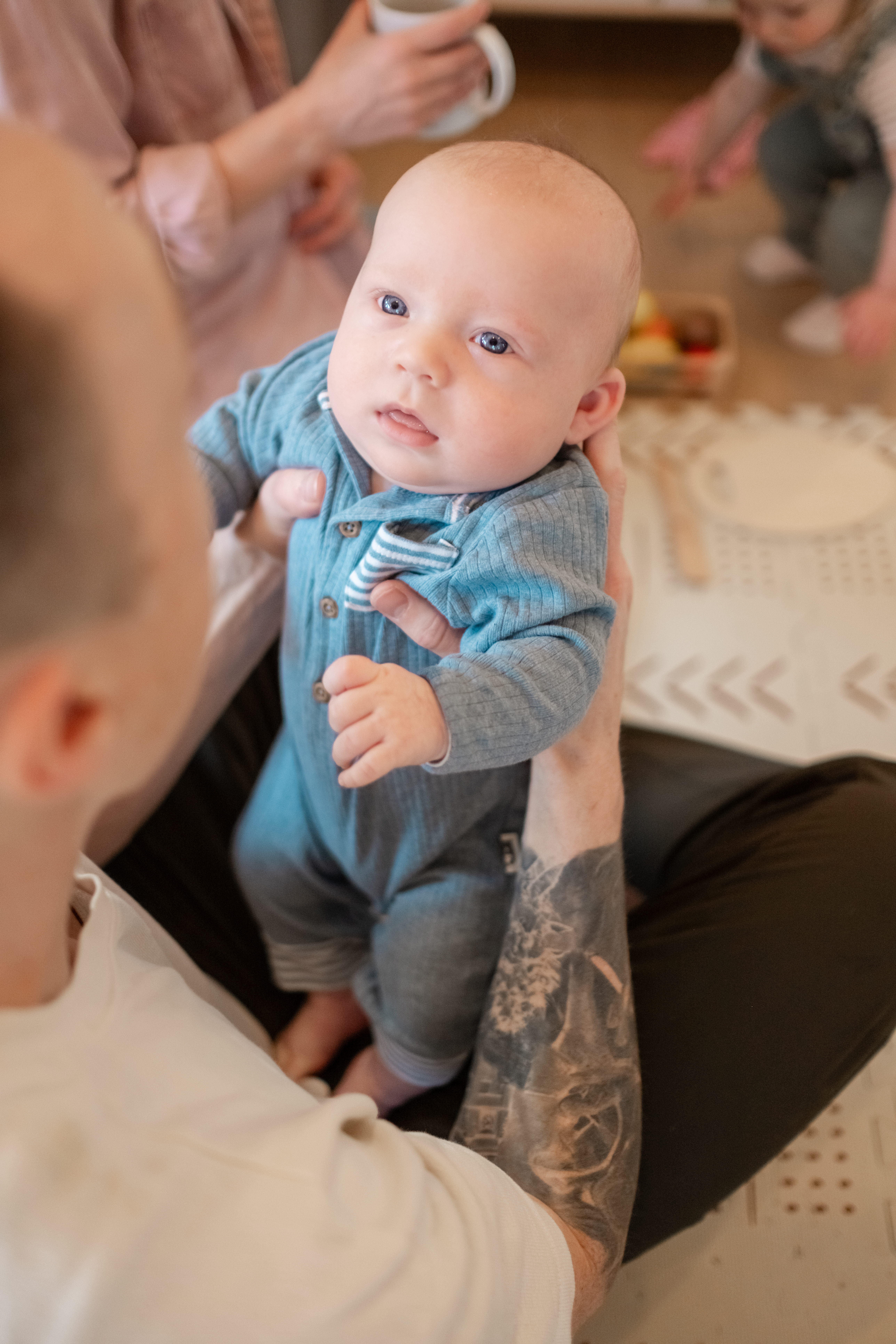 Picture of a Seattle Dad holding his baby boy while playing in living room with his family